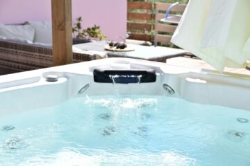 Uma mulher relaxa feliz em uma banheira de hidromassagem completa.